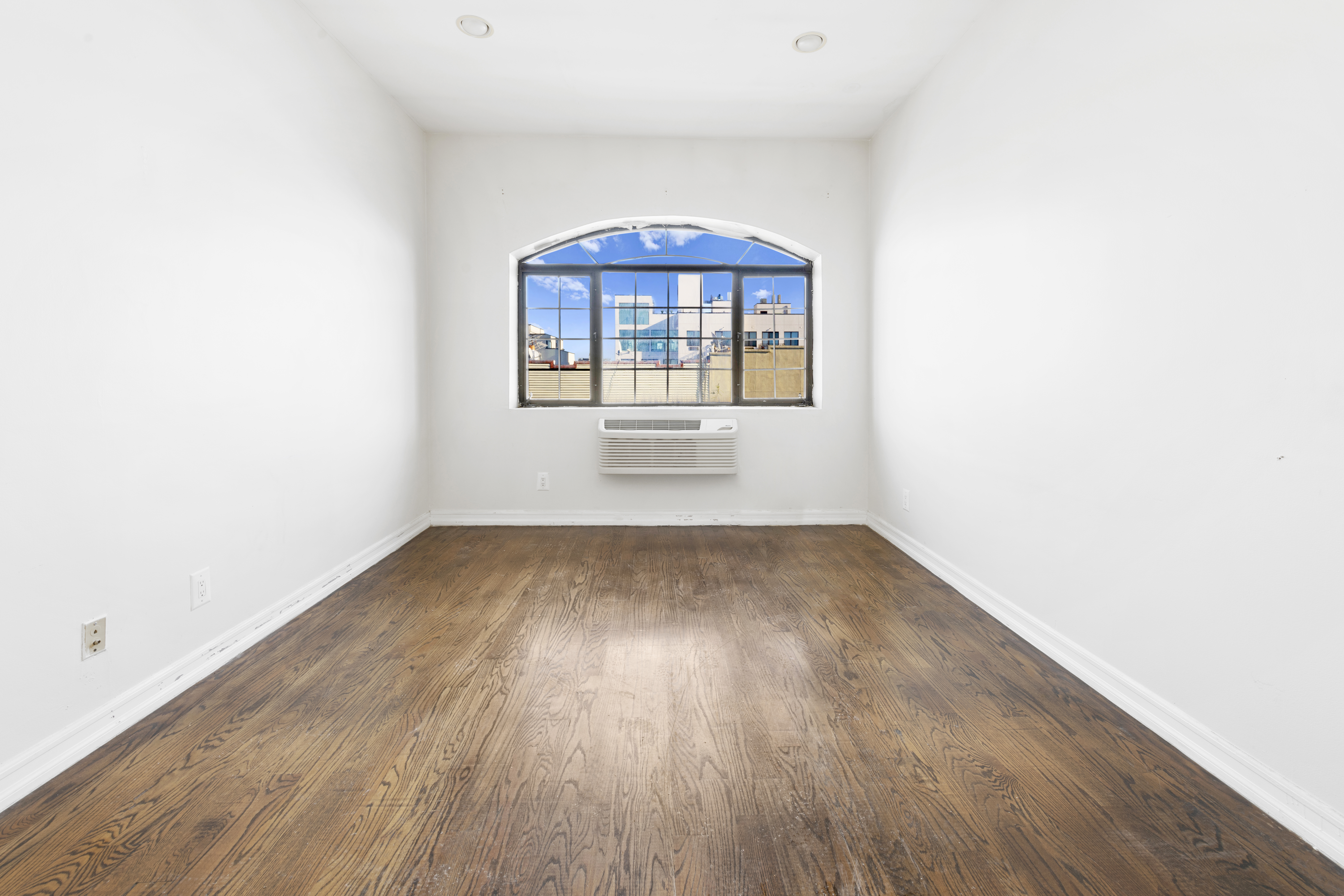 221 Troutman Street, Unit 4L Brooklyn, NY 11237 - Photo 4 of 11 a view of empty room with wooden floor and fan