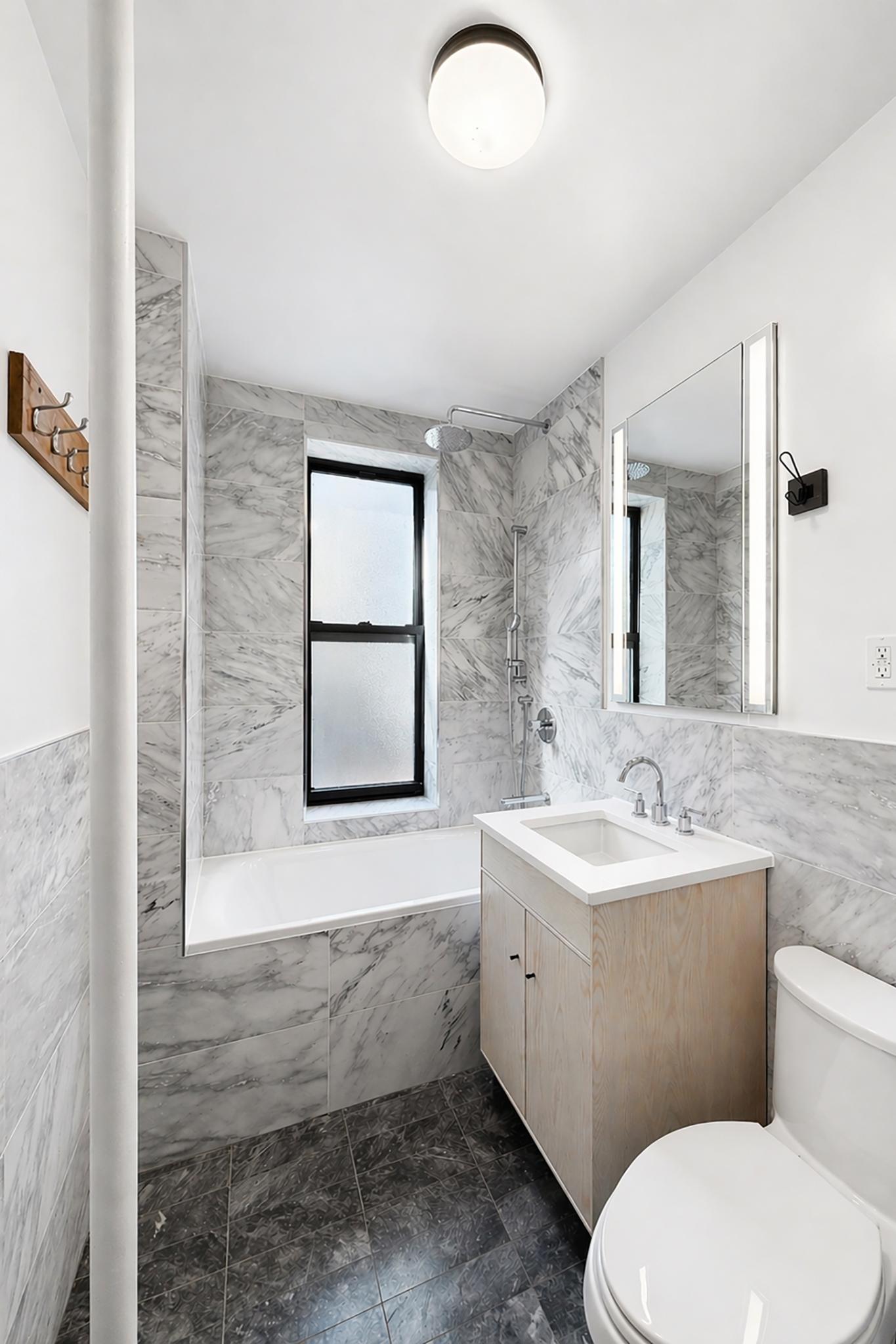 24-39 38th Street, Unit B10B9 Queens, NY 11103 - Photo 9 of 20 a bathroom with a toilet a sink and mirror