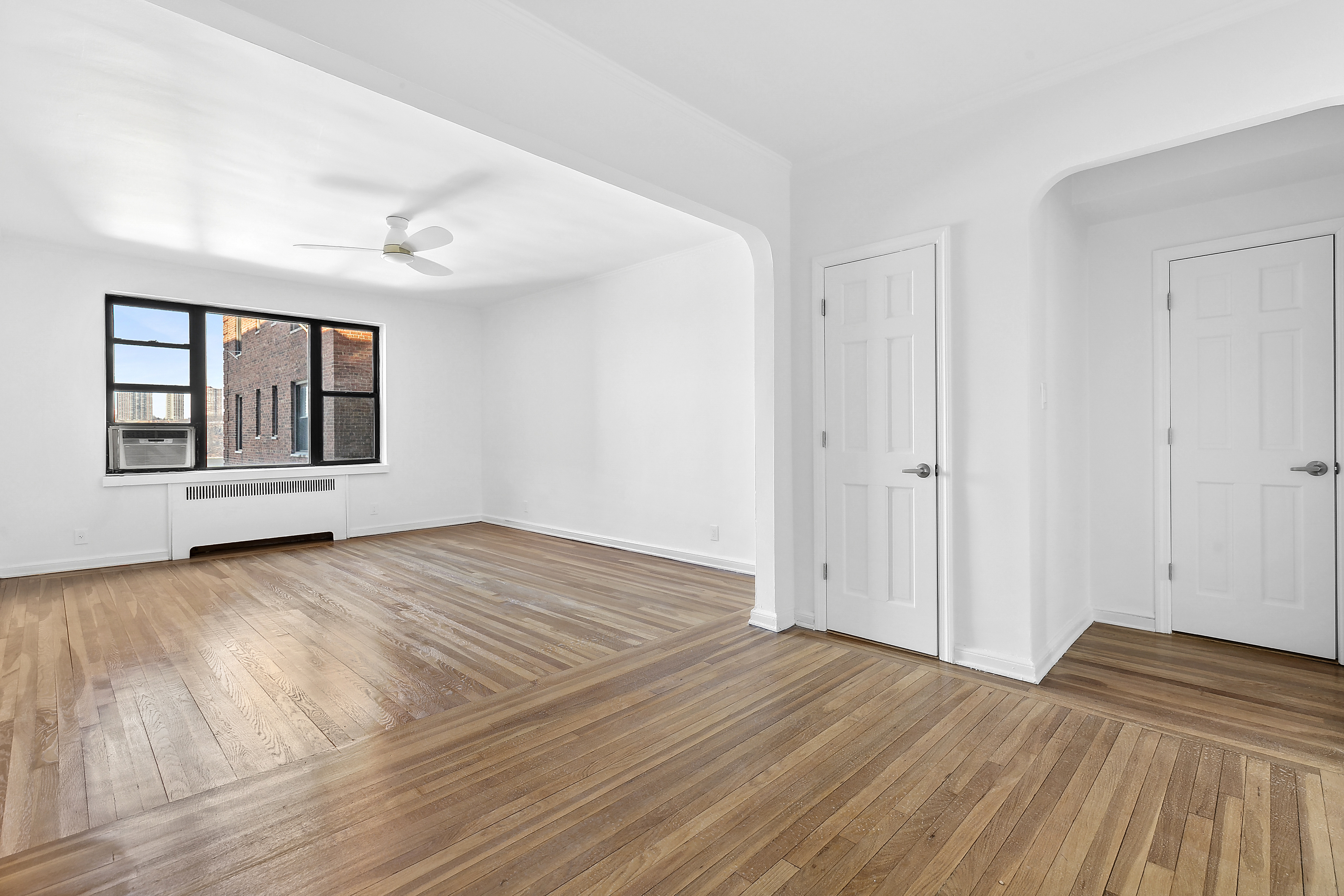 159-34 Riverside Drive West, Unit 5F90 Manhattan, NY 10032 - Photo 2 of 23 a view of empty room with wooden floor and fan