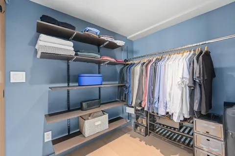 a view of walk in closet with clothes and shoes