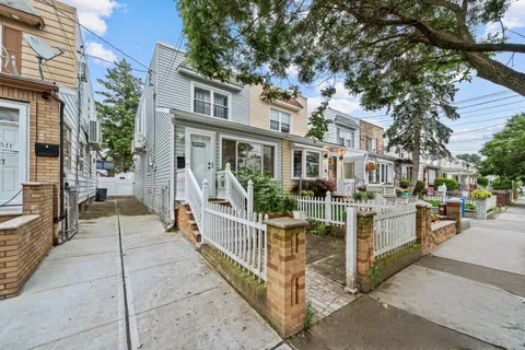 a view of a house with a small yard and wooden fence