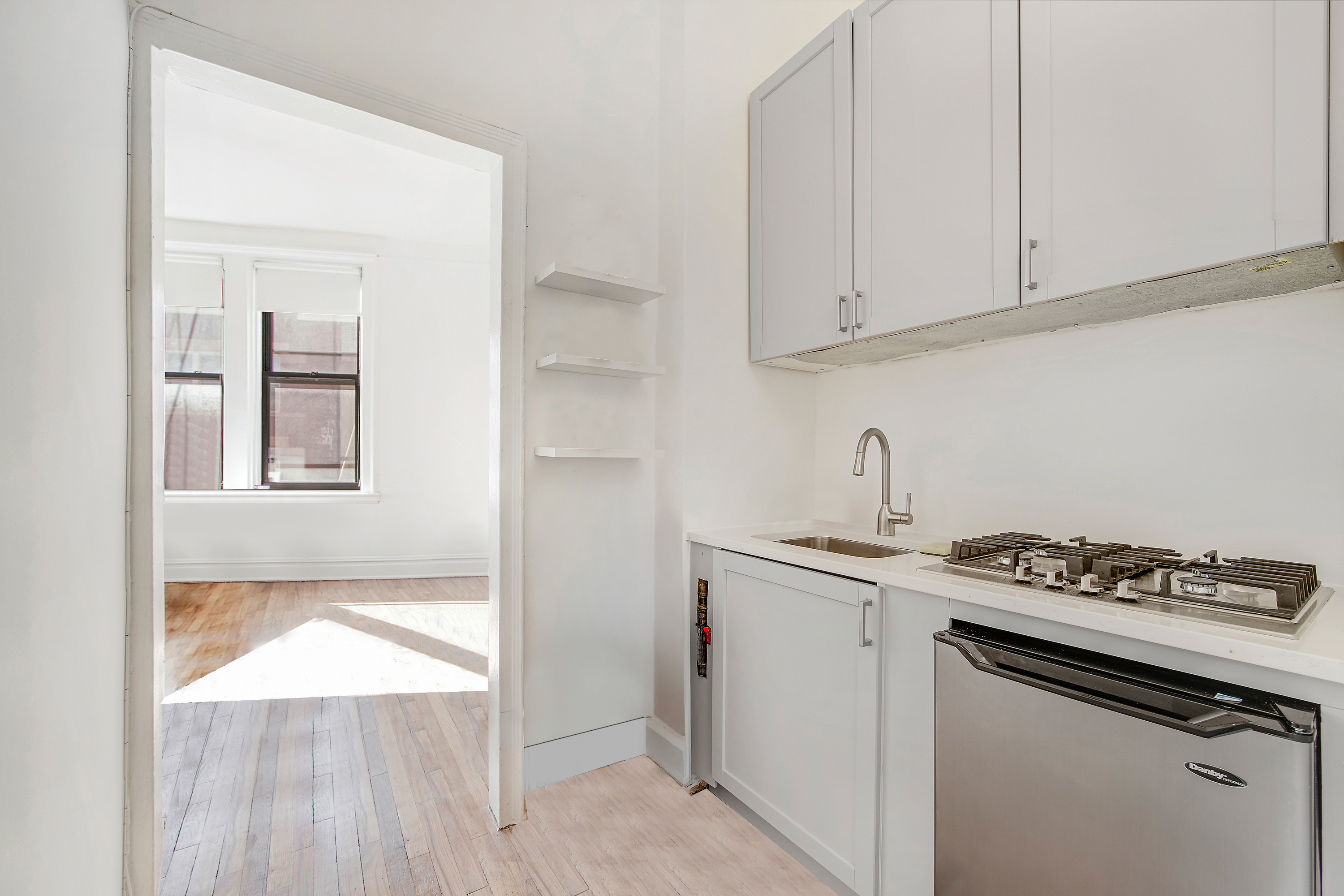 1 Sheridan Square, Unit 4E Manhattan, NY 10014 - Photo 4 of 10 a kitchen with granite countertop a sink stove and cabinets