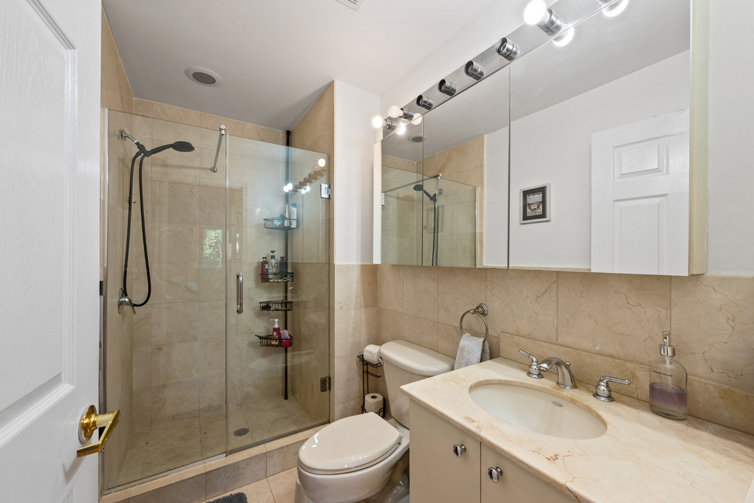 702 Ocean Parkway, Unit 5A Brooklyn, NY 11230 - Photo 8 of 9 a bathroom with a sink toilet granite shower and a mirror