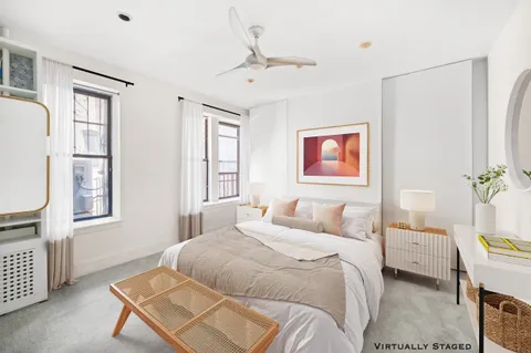 a bedroom with a bed a window and potted plant