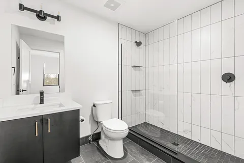 a bathroom with a toilet a sink and shower