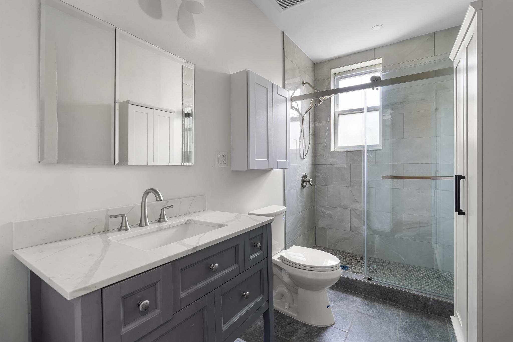880 Park Place, Unit 2 Brooklyn, NY 11216 - Photo 11 of 12 a bathroom with a shower sink vanity mirror and toilet