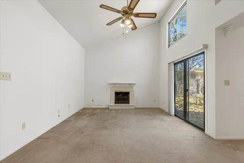 an empty room with windows and a fireplace