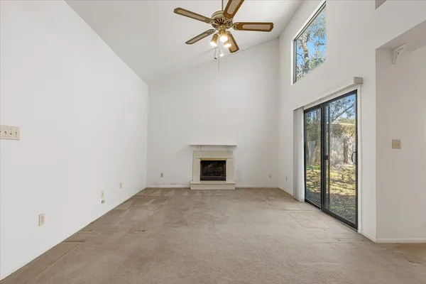 an empty room with windows and a fireplace