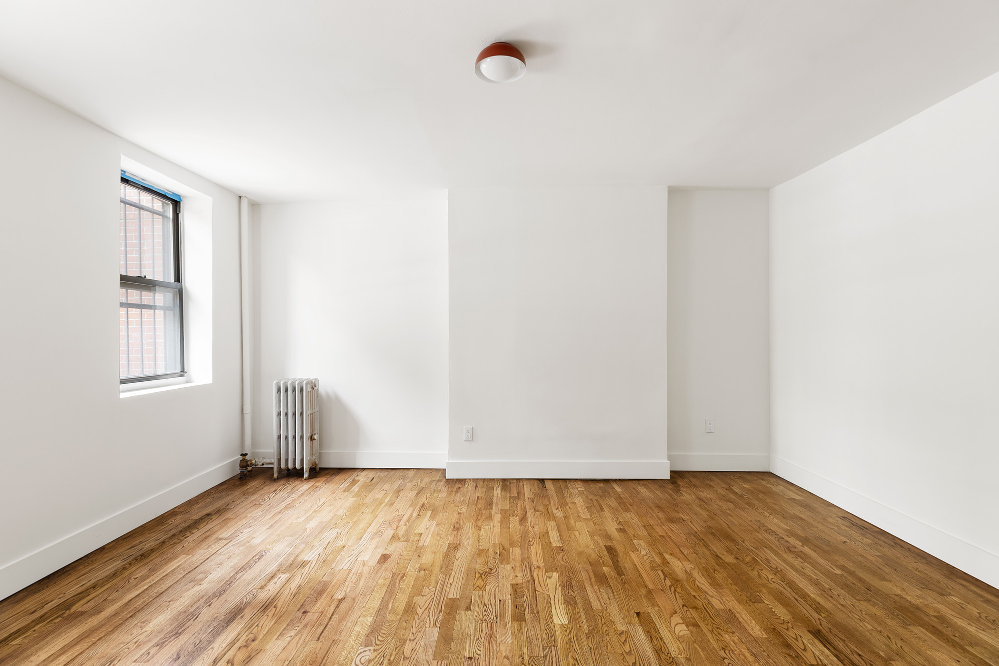 306 Gates Avenue, Unit 1A Brooklyn, NY 11216 - Photo 4 of 14 a view of empty room with wooden floor and fan
