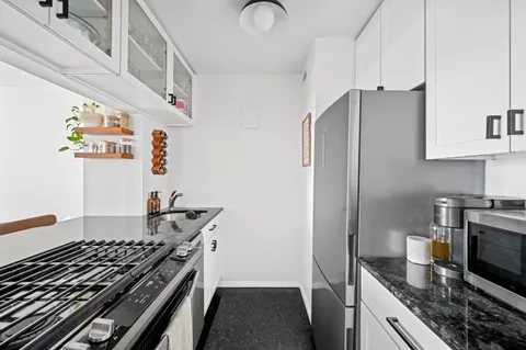 a kitchen with granite countertop a stove and a refrigerator