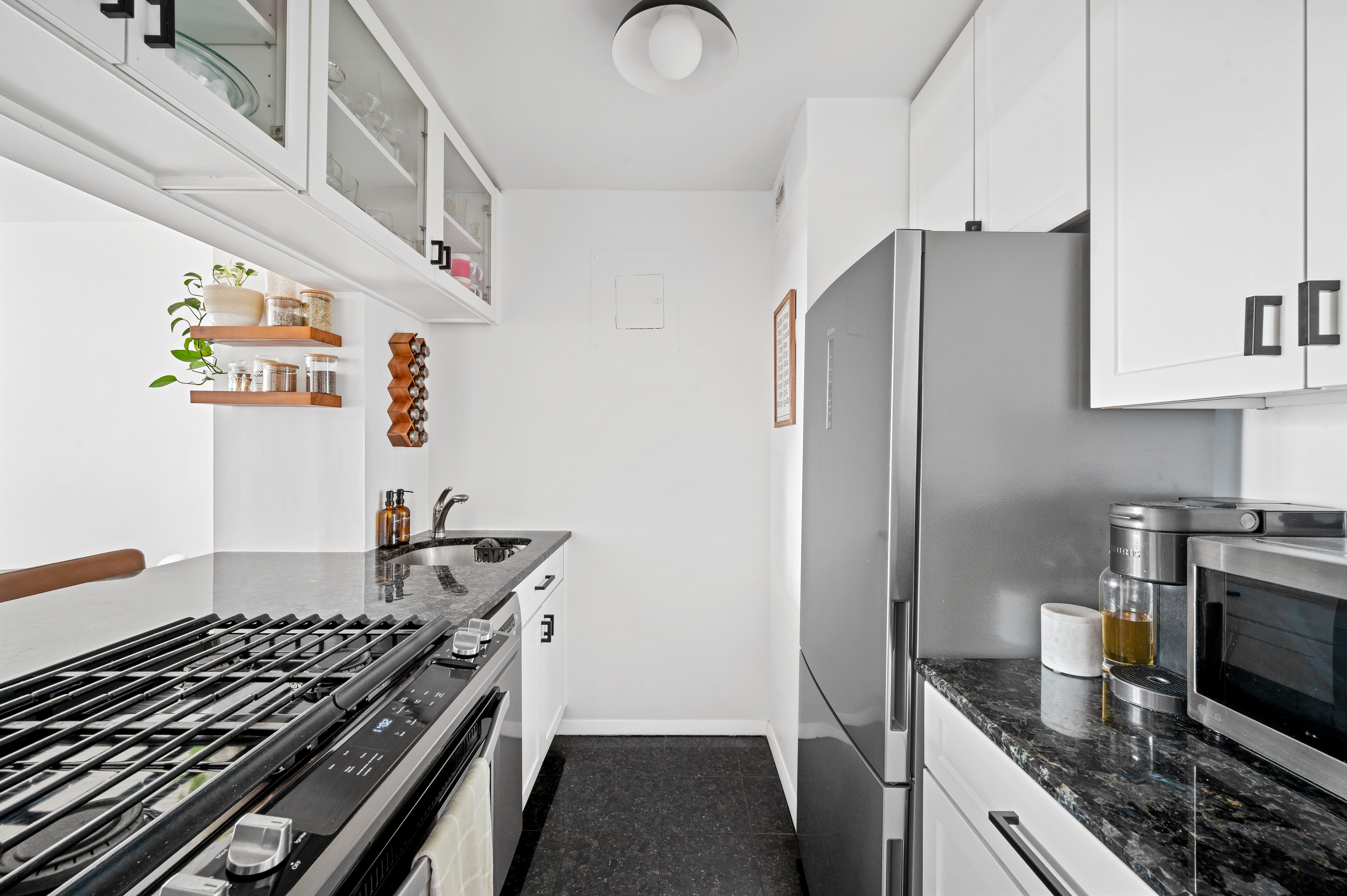 245 East 54th Street, Unit 26JK Manhattan, NY 10022 - Photo 4 of 12 a kitchen with granite countertop a stove and a refrigerator