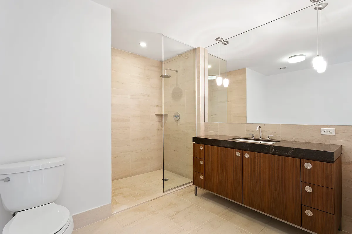 57 Reade Street, Unit 14C Manhattan, NY 10007 - Photo 11 of 16 a bathroom with a sink a toilet and shower