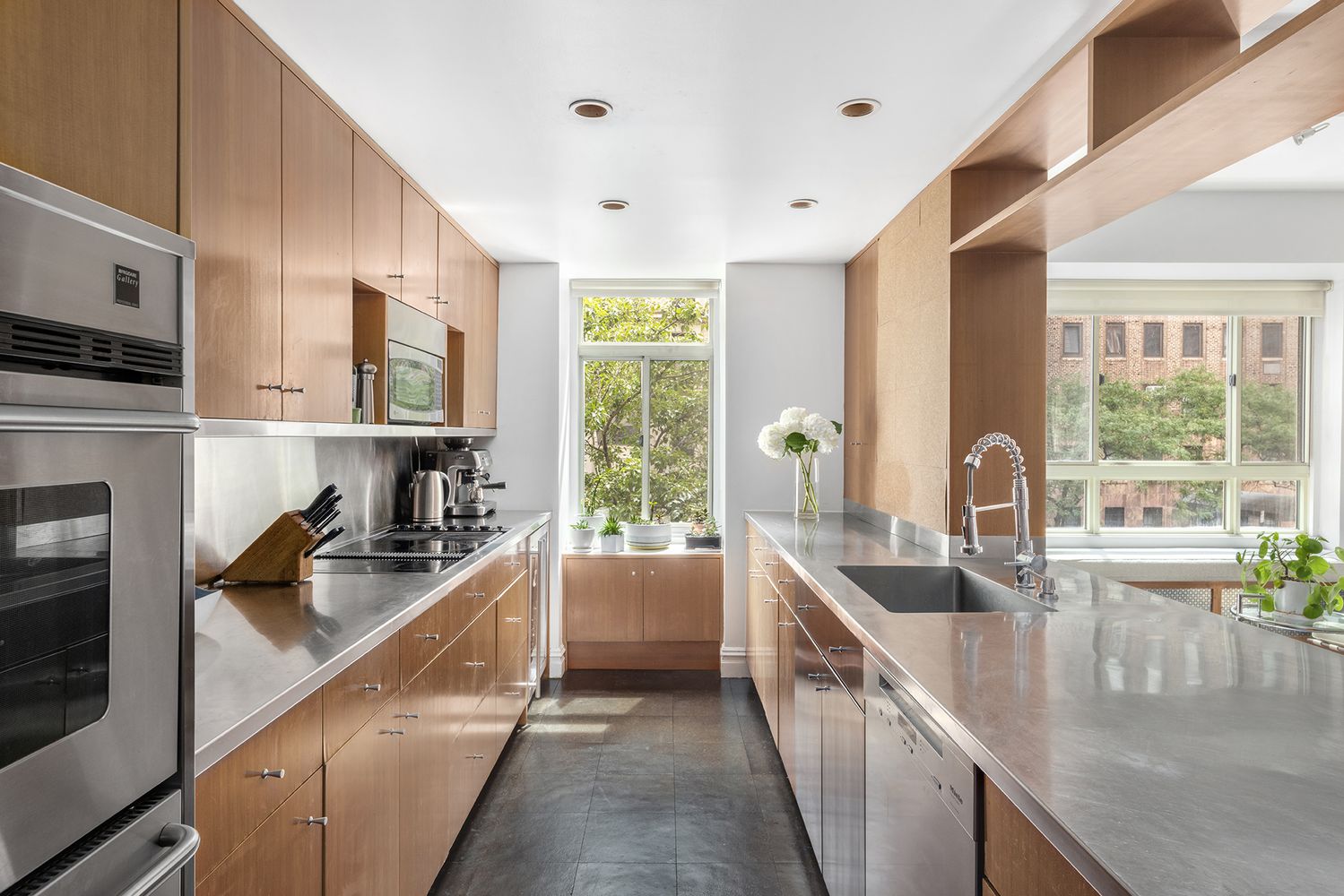 a kitchen with stainless steel appliances granite countertop a sink a stove and a refrigerator