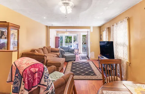 a living room with furniture a flat screen tv and a window