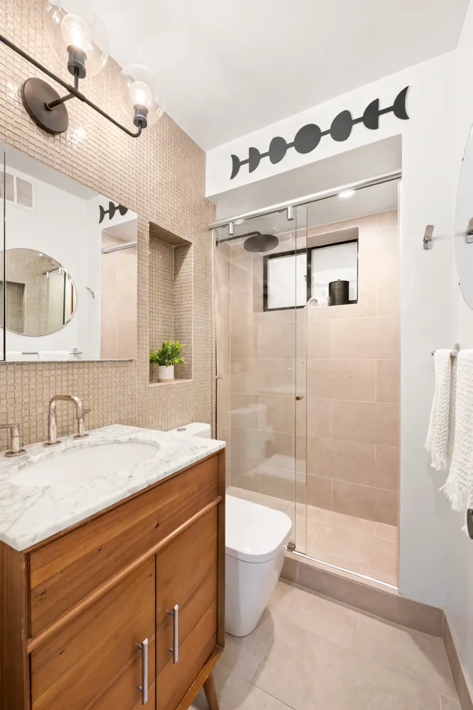 a bathroom with a sink a toilet and shower