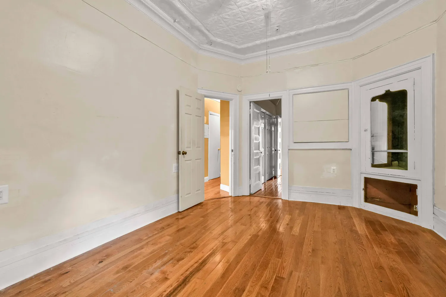 a view of empty room with wooden floor