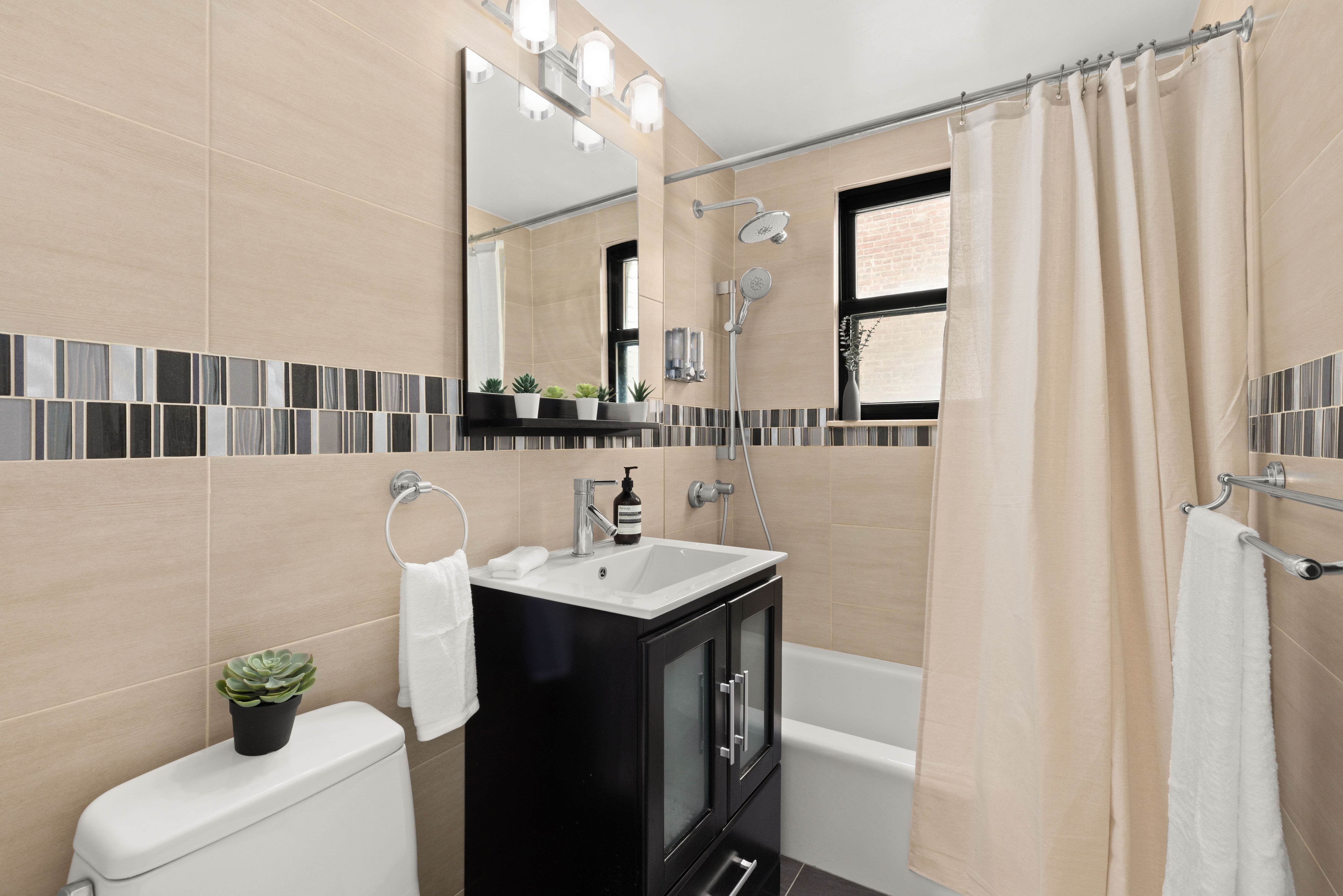 150 East 56th Street, Unit 2A Manhattan, NY 10022 - Photo 6 of 10 a bathroom with a sink a toilet and mirror