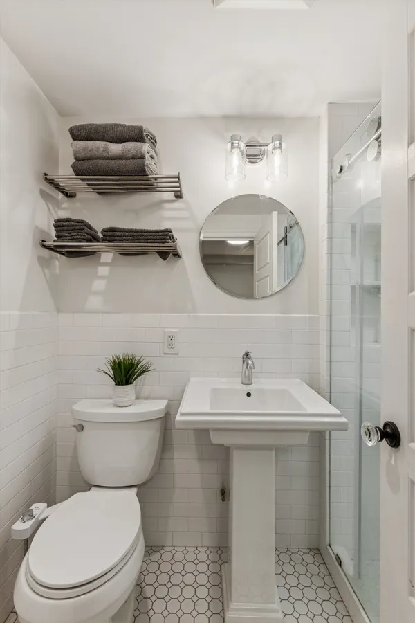 a bathroom with a sink a toilet and a mirror