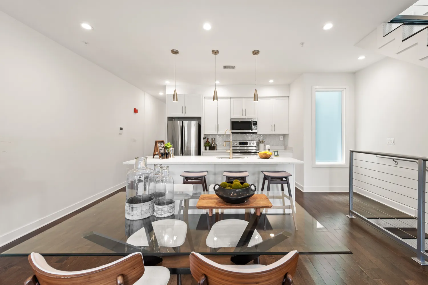 a kitchen with stainless steel appliances a dining table and chairs