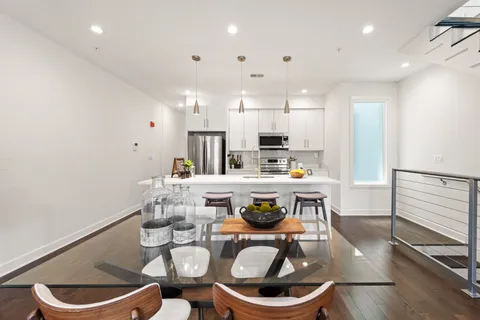 a kitchen with stainless steel appliances a dining table and chairs