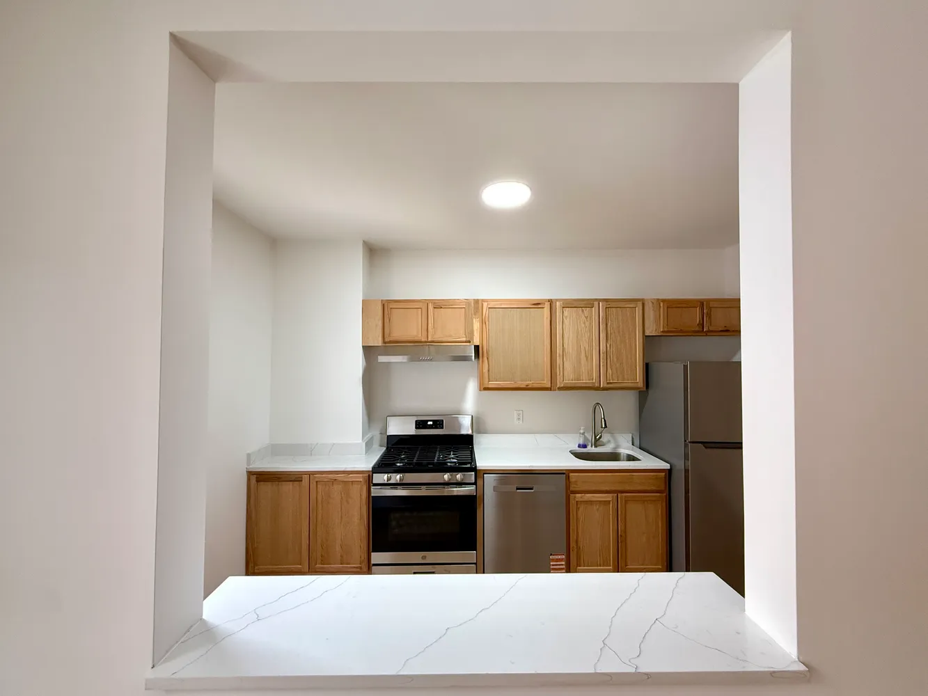 a kitchen with stainless steel appliances a sink stove and refrigerator