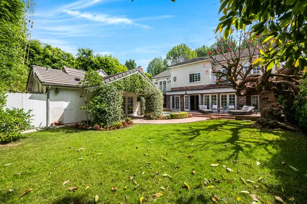 a front view of house with yard and trees in the background