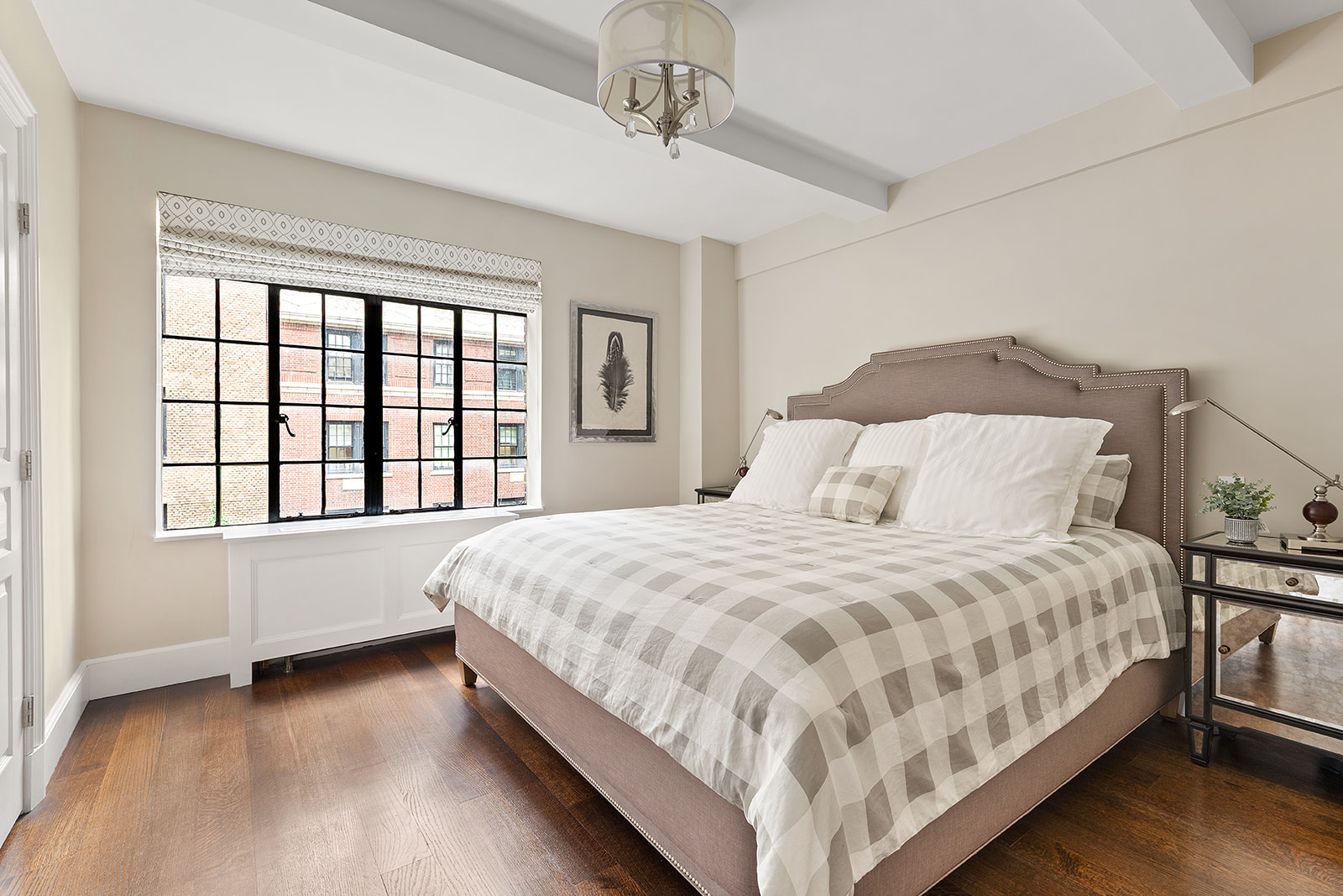 71 East 77th Street, Unit 8A Manhattan, NY 10075 - Photo 4 of 9 a bedroom with a bed lamp and a large window