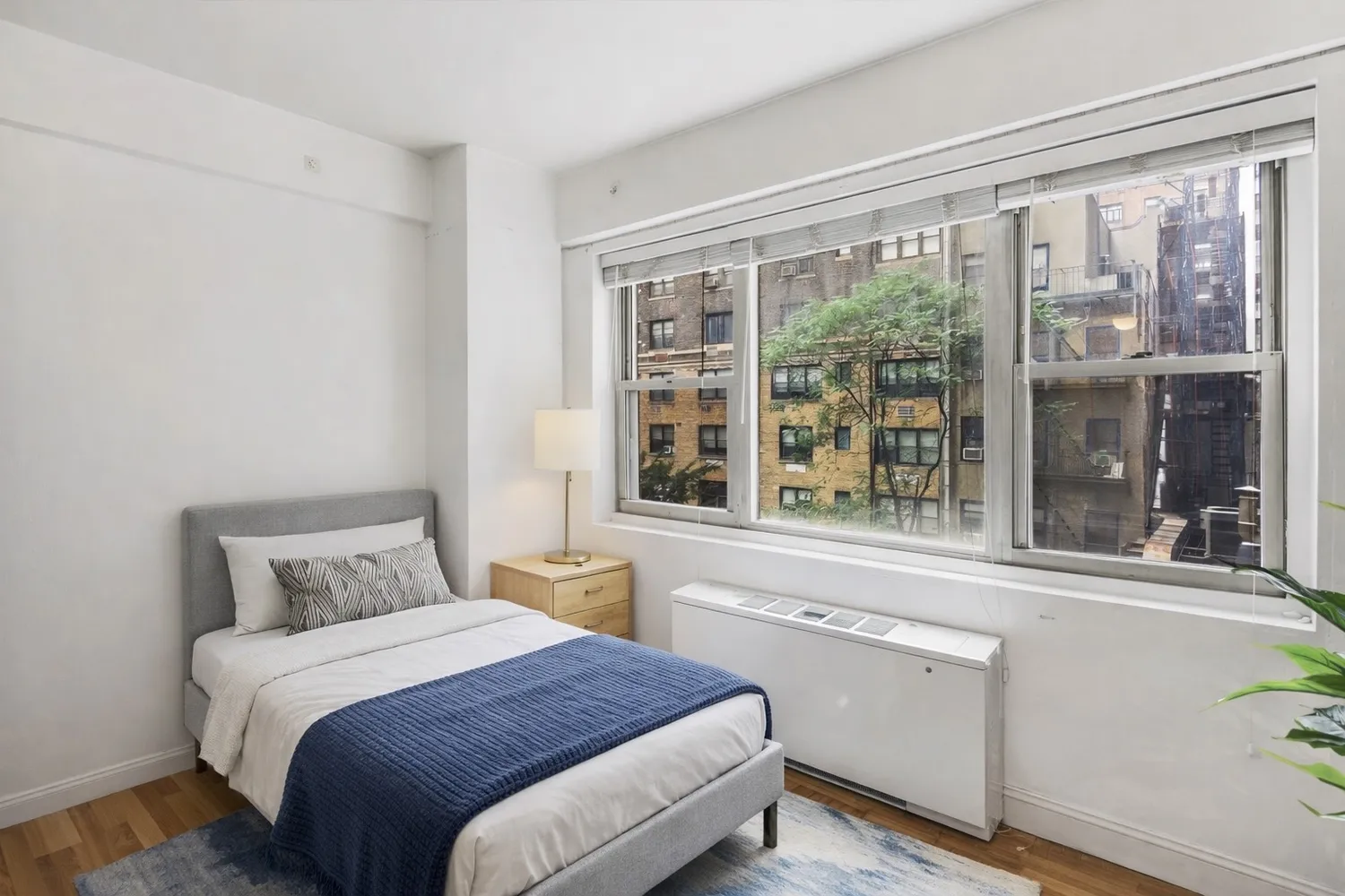a bedroom with a bed and a large window with outer view