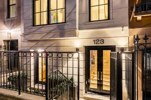 a front view of a building with a lot of windows and plants