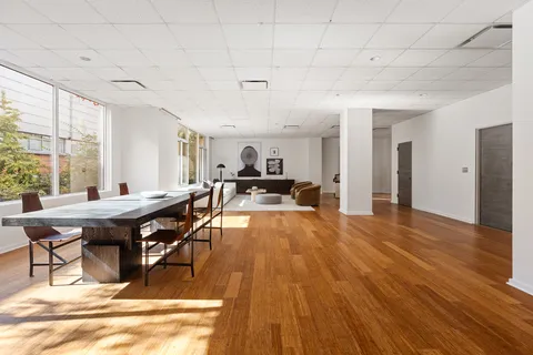 a living room with furniture a wooden floor and next to a window
