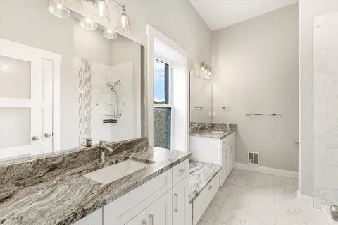 a spacious bathroom with a granite countertop sink mirror and a
