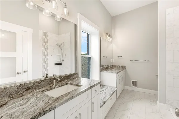 a spacious bathroom with a granite countertop sink mirror and a