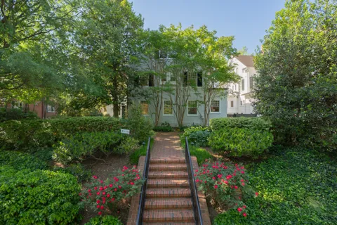 a view of a pathway of a house with flower garden
