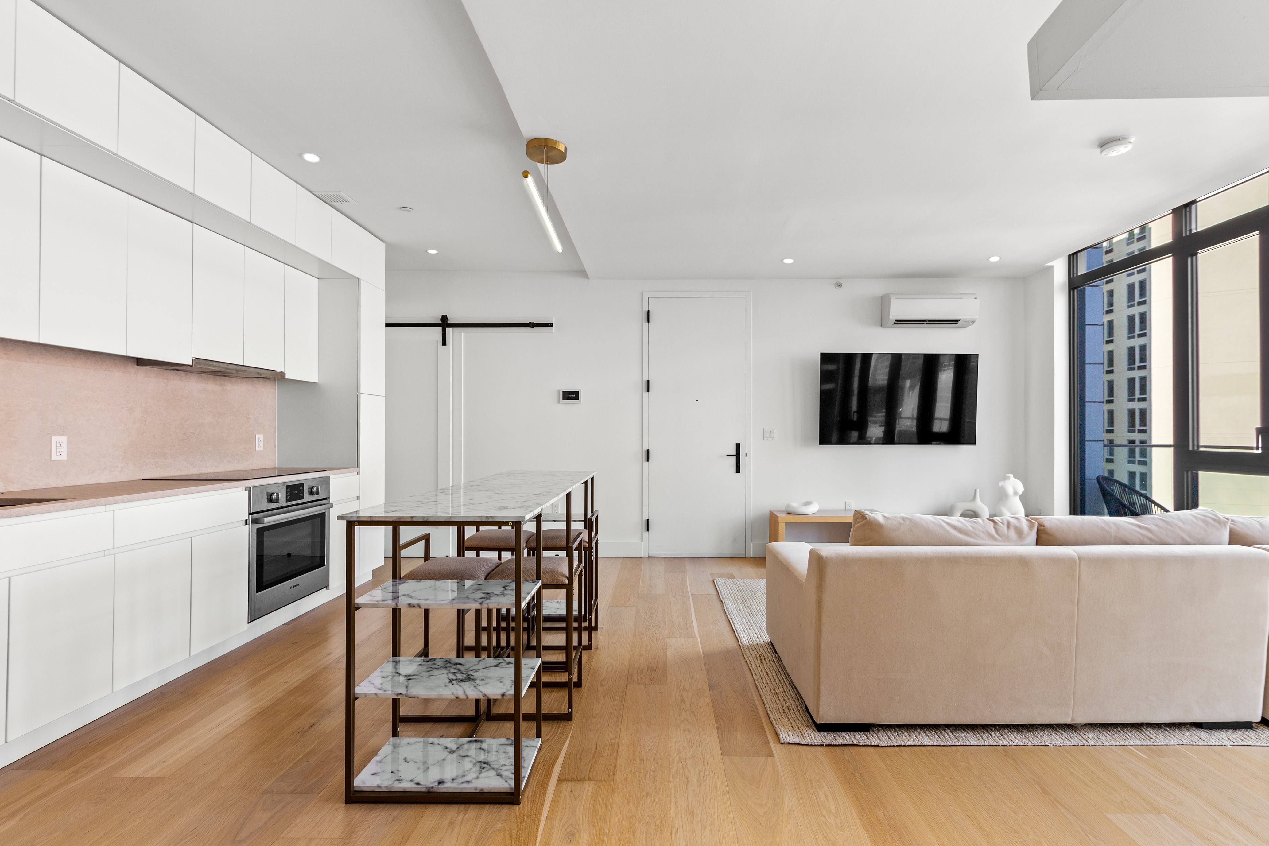 112 Fleet Place, Unit 12A Brooklyn, NY 11201 - Photo 5 of 15 a living room with furniture wooden floor and a kitchen view
