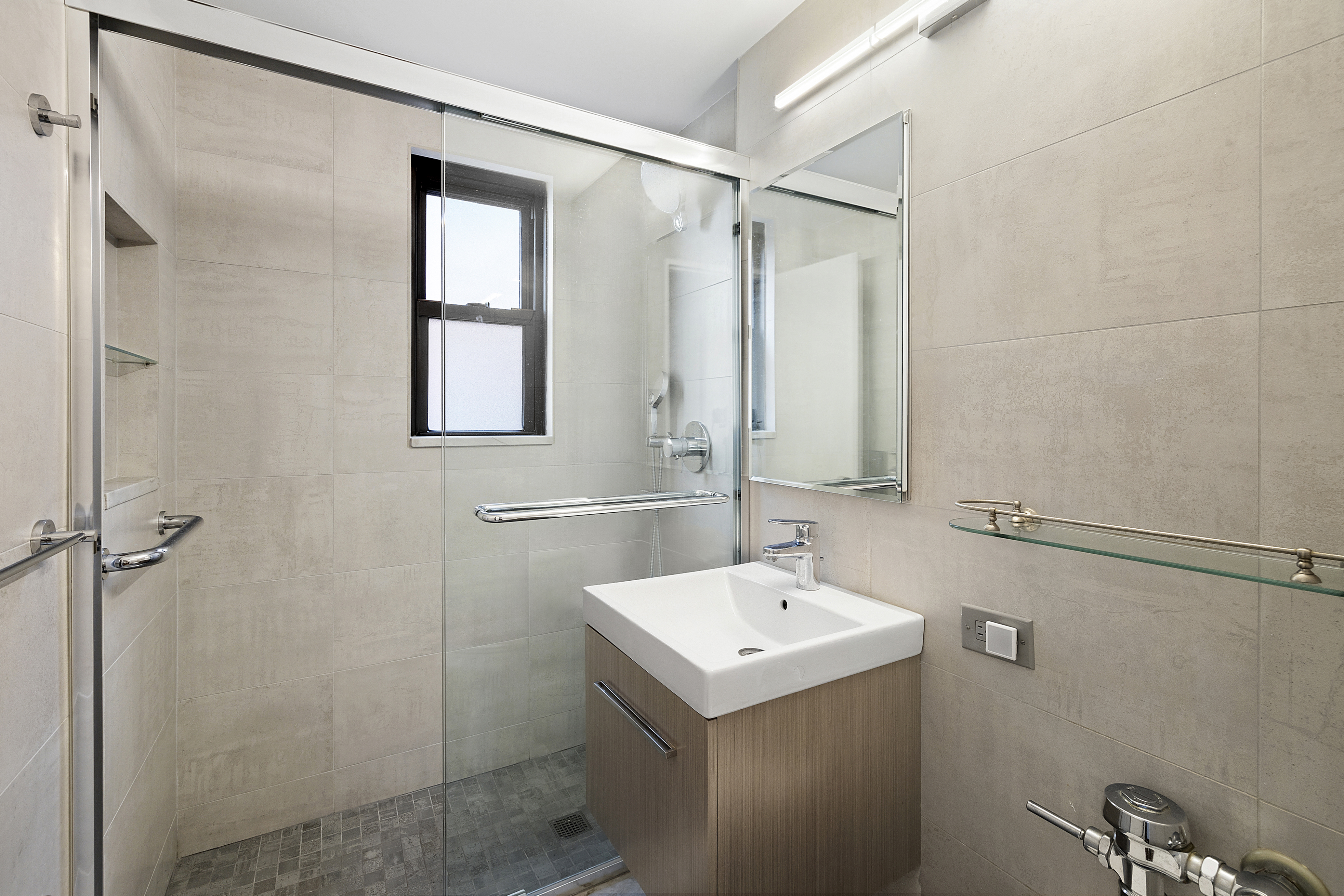 54 West 16th Street, Unit 6F Manhattan, NY 10011 - Photo 5 of 8 a bathroom with a sink a mirror and a shower