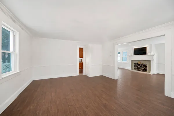 a view of a livingroom with wooden floor and a fireplace