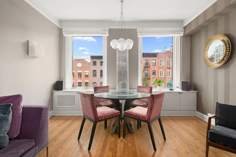 a dining room with furniture a chandelier and wooden floor