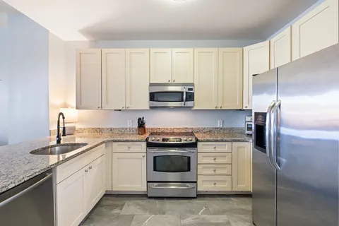 a kitchen with cabinets stainless steel appliances and a sink