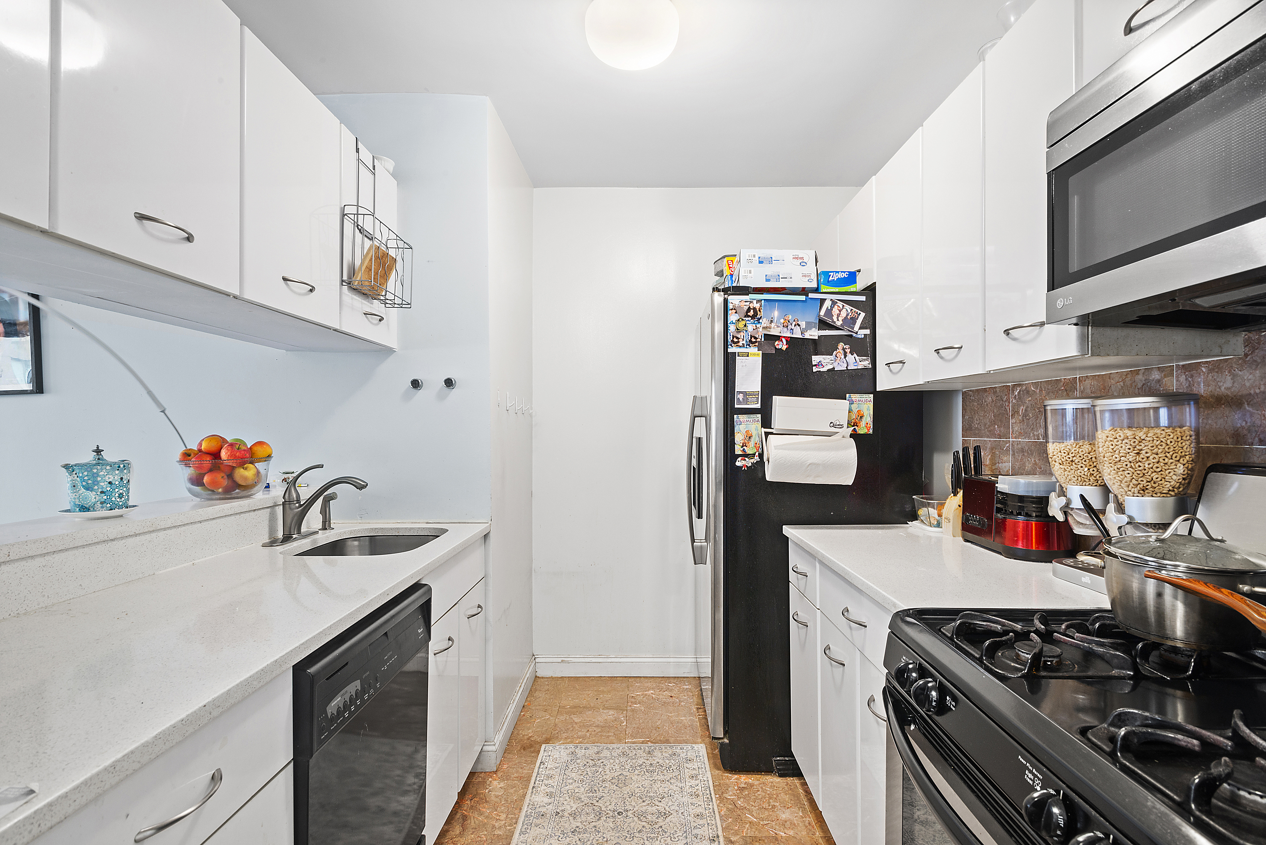 2 South End Avenue, Unit 9E Manhattan, NY 10280 - Photo 5 of 7 a kitchen with stainless steel appliances granite countertop a lot of cabinets a stove and a refrigerator