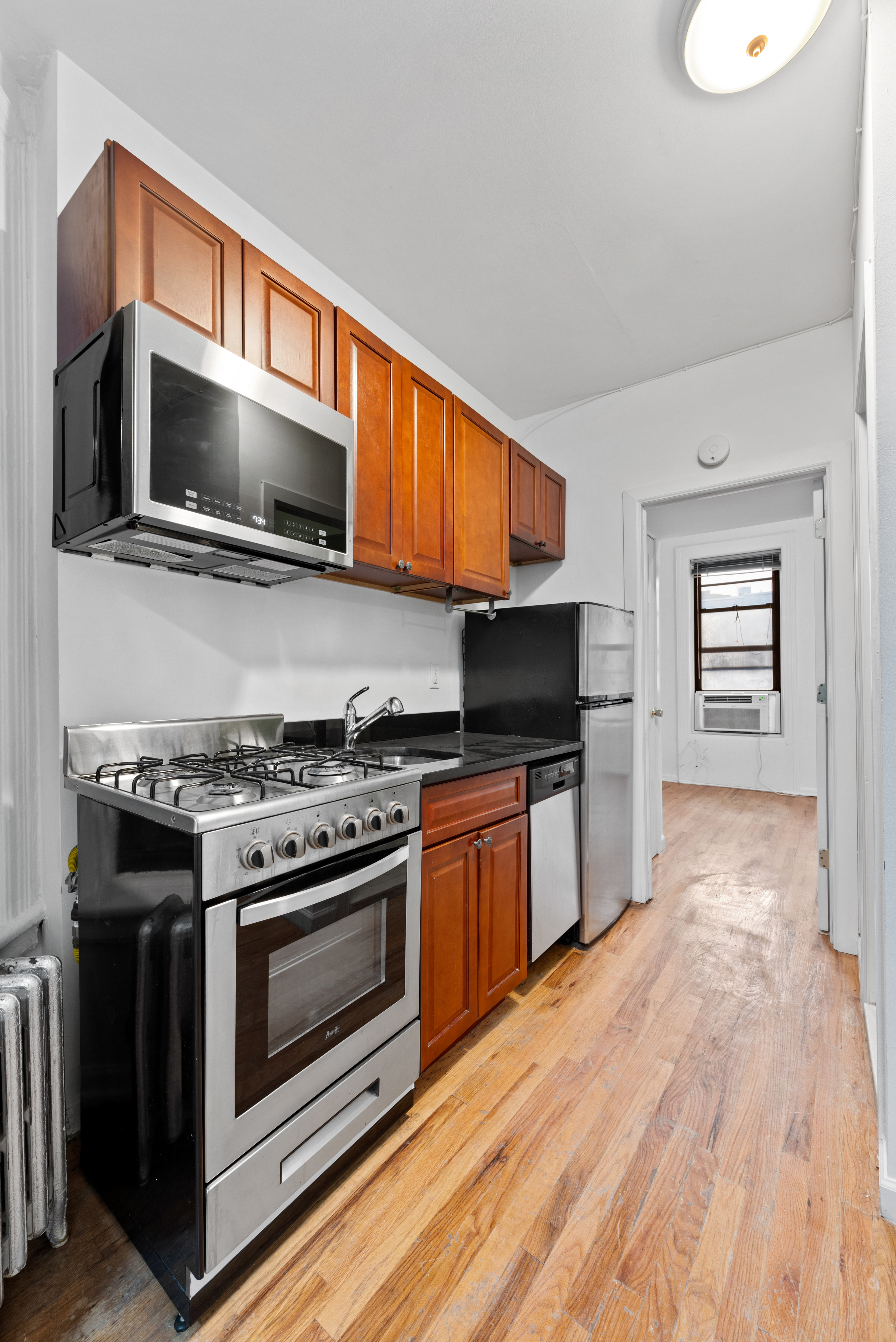 142 Sullivan Street, Unit 18 Manhattan, NY 10012 - Photo 3 of 11 a kitchen with a stove and a microwave