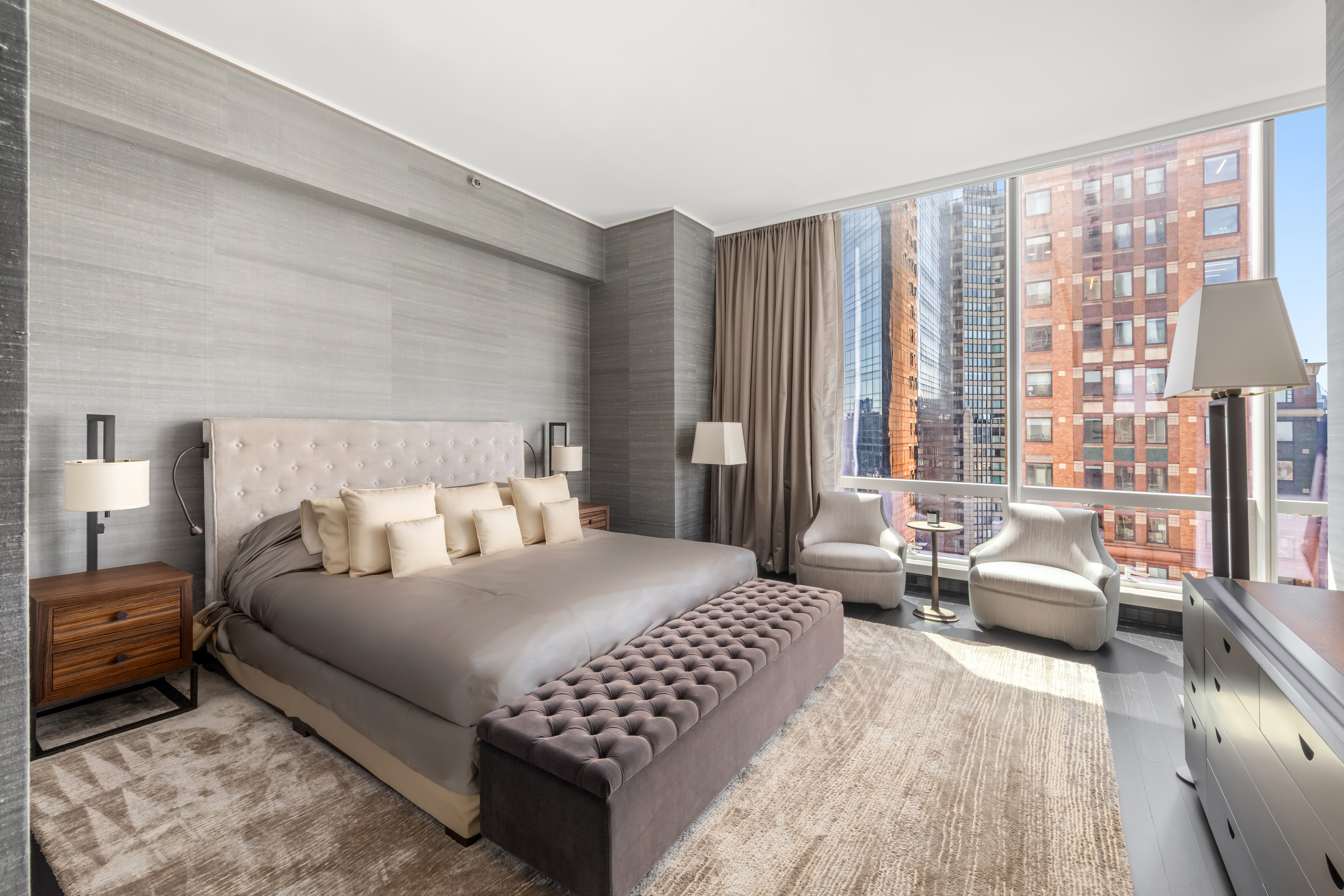 157 West 57th Street, Unit 50B Manhattan, NY 10019 - Photo 8 of 18 a bedroom with a bed couch and a large window