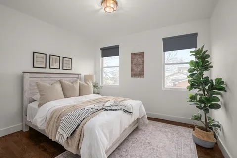 a bedroom with a bed and a potted plant
