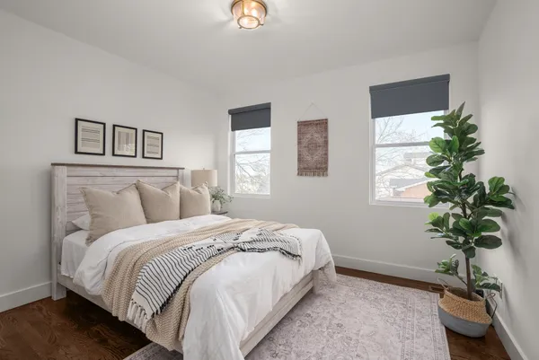 a bedroom with a bed and a potted plant