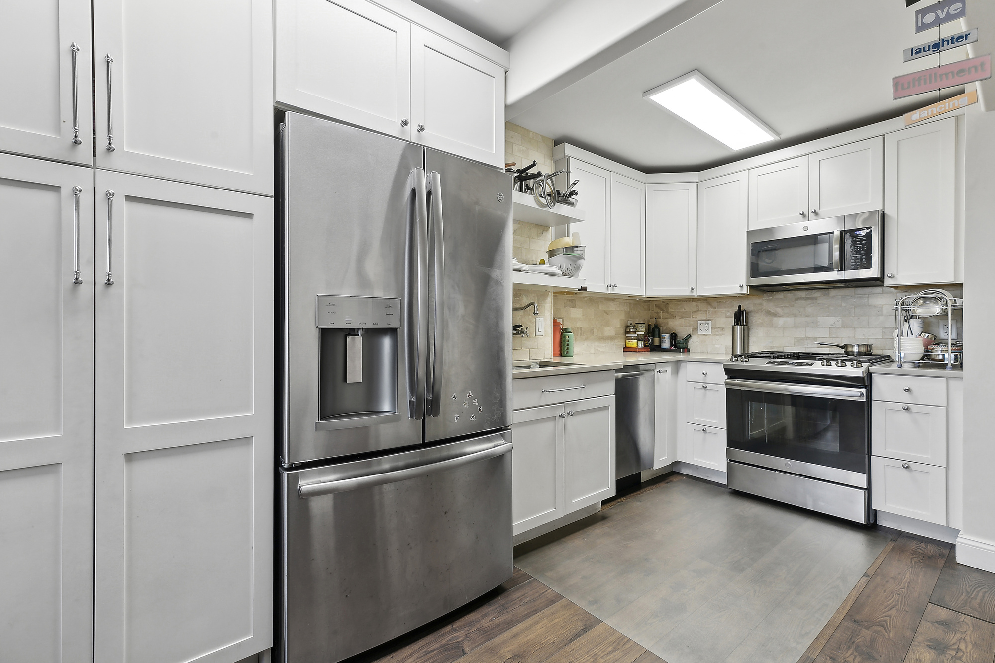 200 Rector Place, Unit 26B Manhattan, NY 10280 - Photo 3 of 8 a kitchen with stainless steel appliances a refrigerator sink and microwave