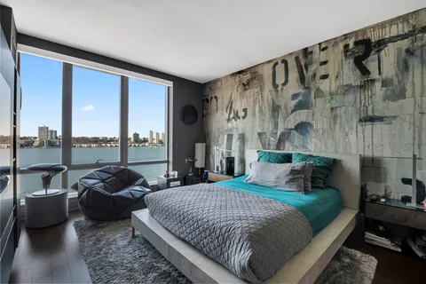 a bedroom with a bed and glass walk in closet