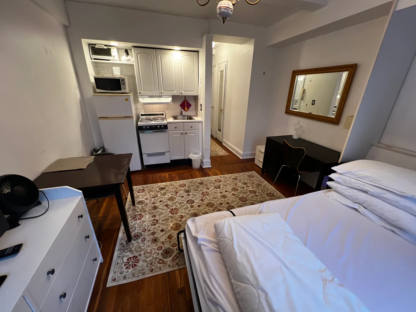 a bedroom with a bed and a mirror on the dresser