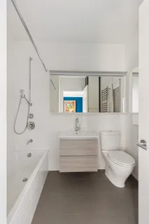 a bathroom with a bathtub shower sink vanity and toilet