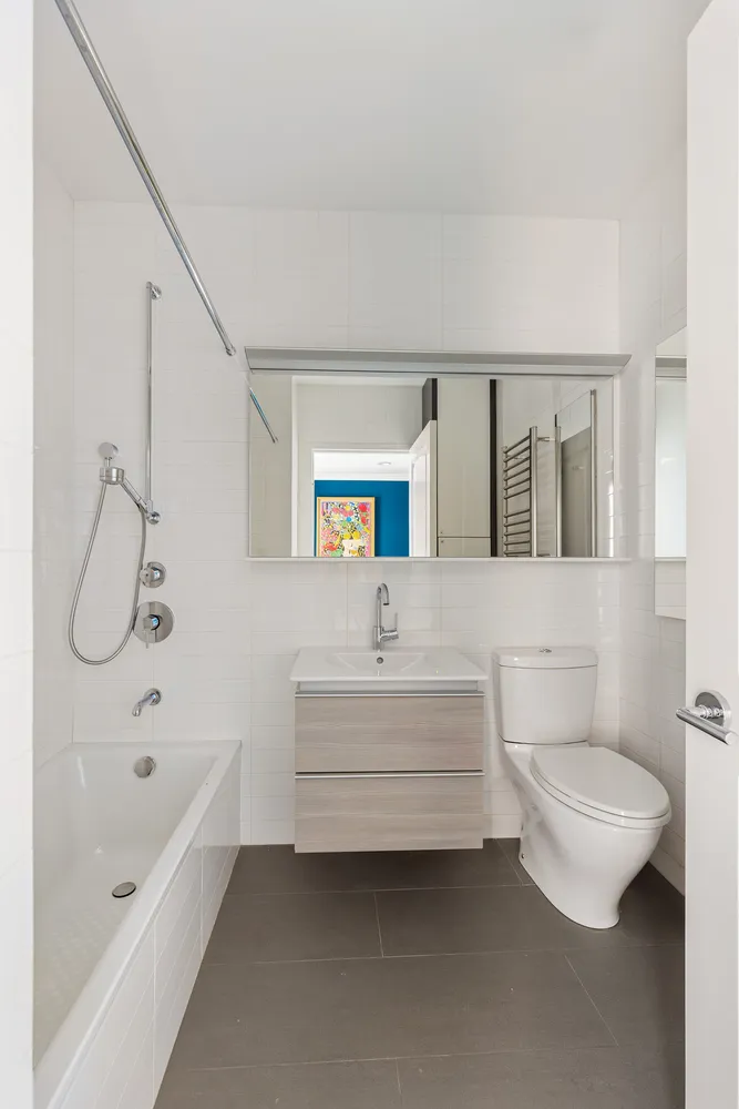 a bathroom with a bathtub shower sink vanity and toilet