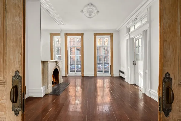 a view of a livingroom with wooden floor a fireplace and windows
