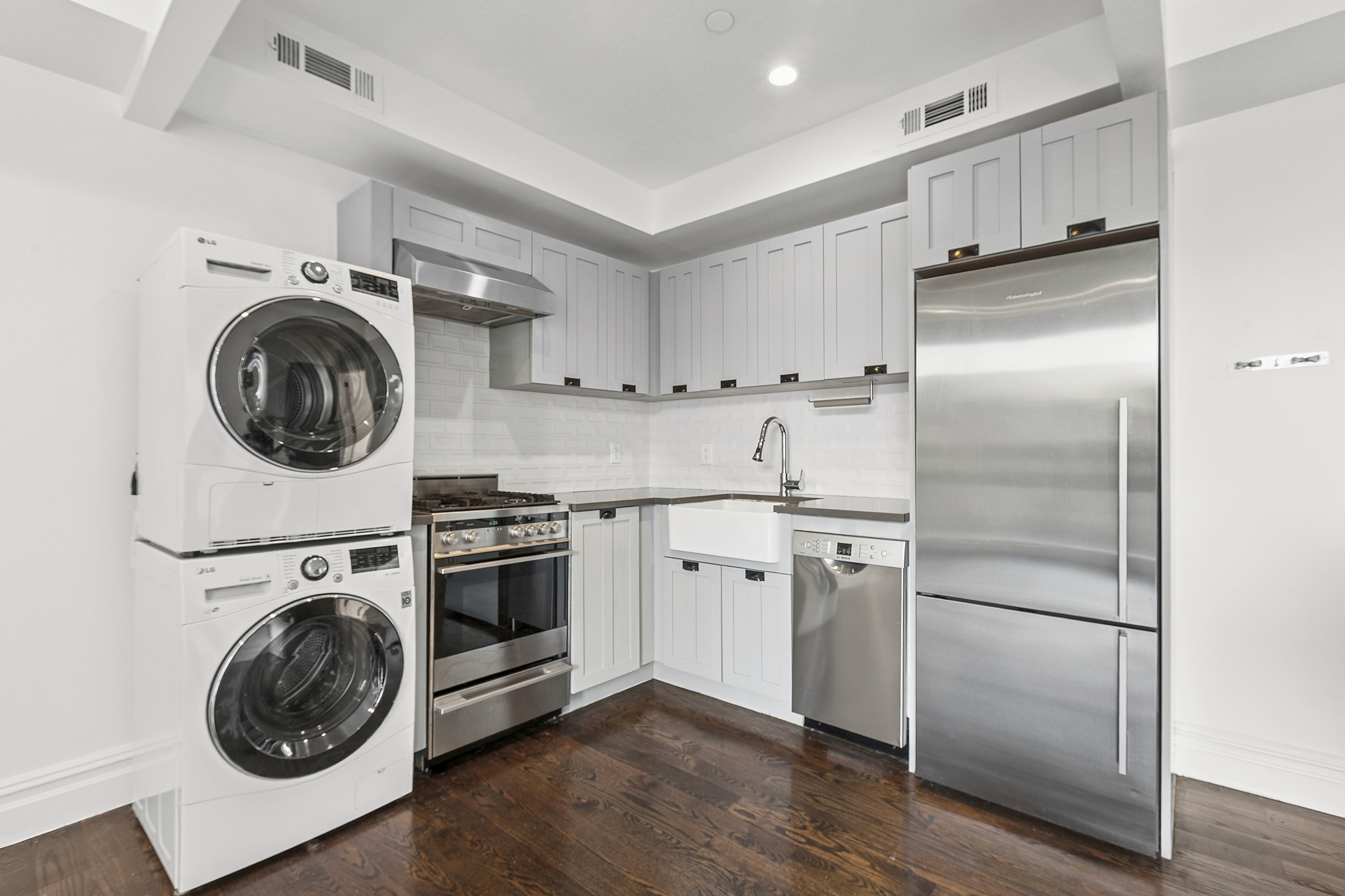 1255 Bushwick Avenue, Unit 3D Brooklyn, NY 11207 - Photo 5 of 6 a kitchen with cabinets stainless steel appliances and wooden floor